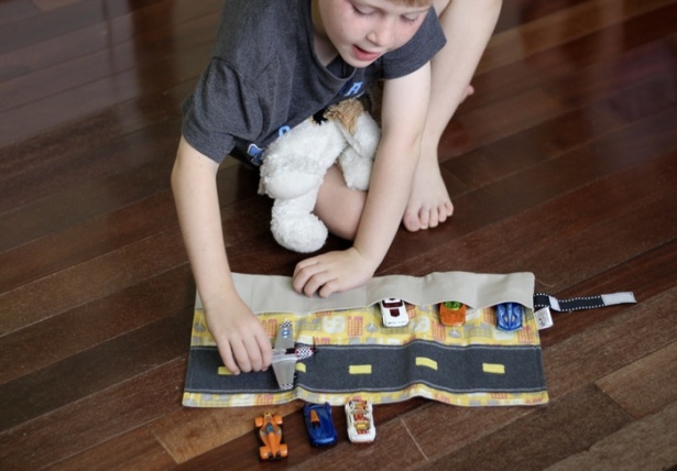 Child playing with an interactive handmade toy from Mouse Loves Pig.
