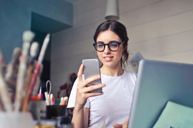 female business owner looking at a phone- Brand Strategy for Resilient Businesses