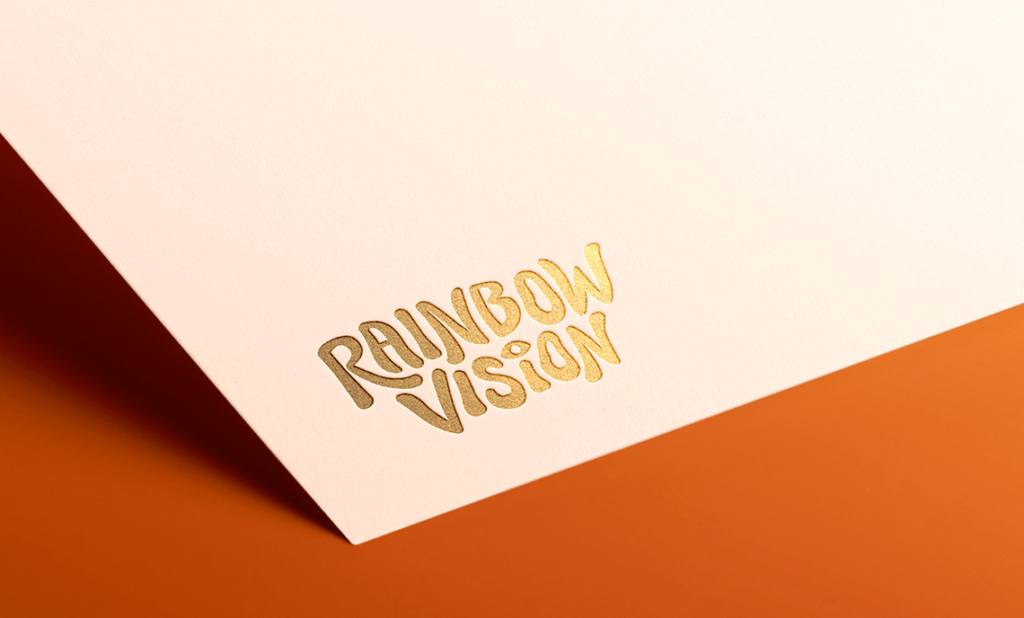 Branding and website case study for Rainbow Vision. Shown here, a custom logo, printed in gold.