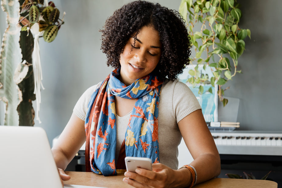 Woman checking her phone for SMS marketing for Shopify stores