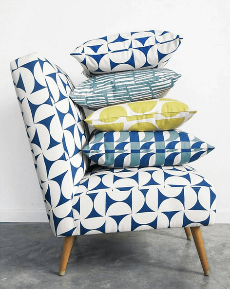 Styled photos like this accent chair with patterned pillows can help drive traffic from instagram to your online shop.